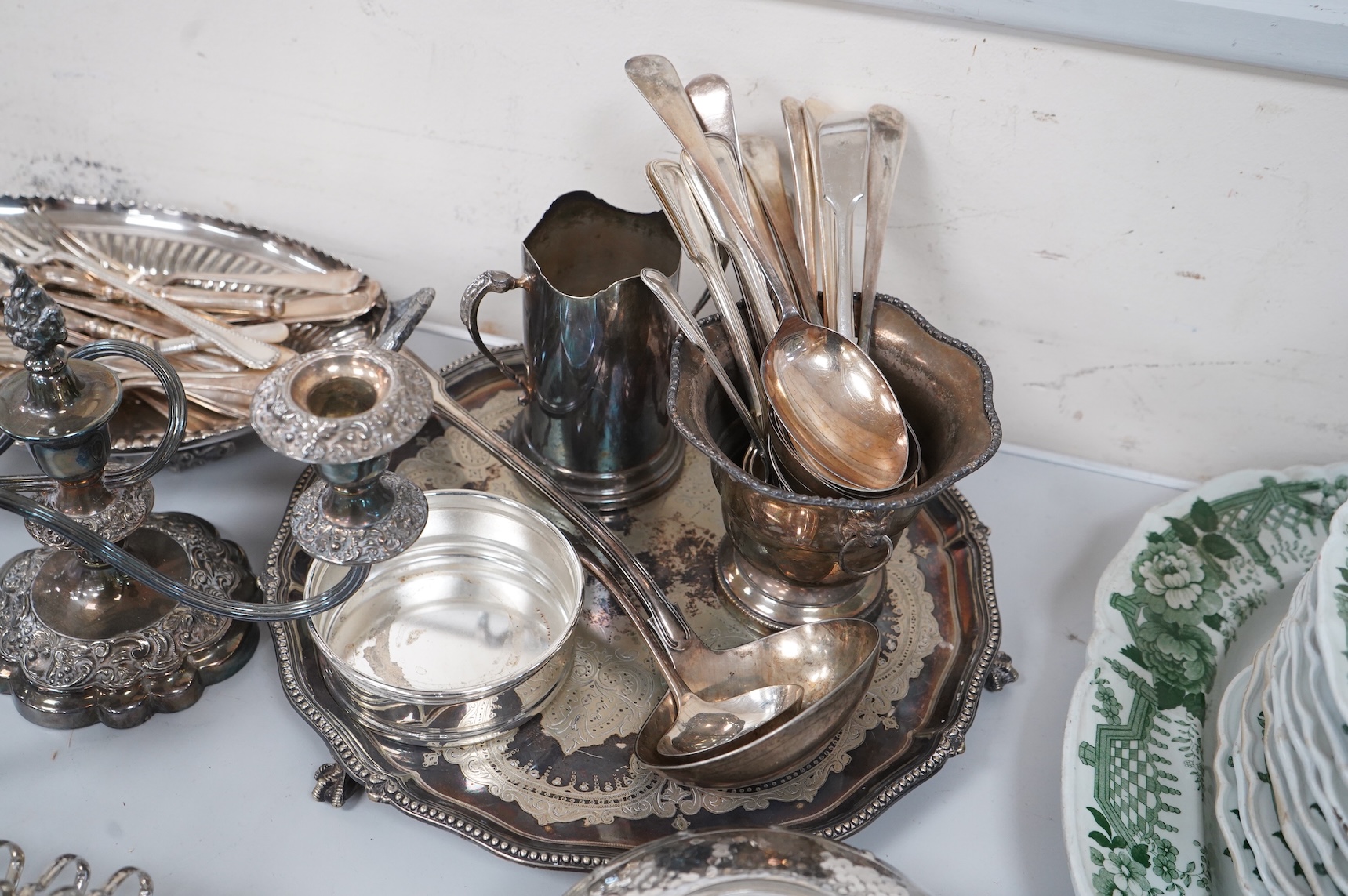 A collection of silver plate to include cased dessert forks, a hammered tea pot, pair of candlesticks and a salver